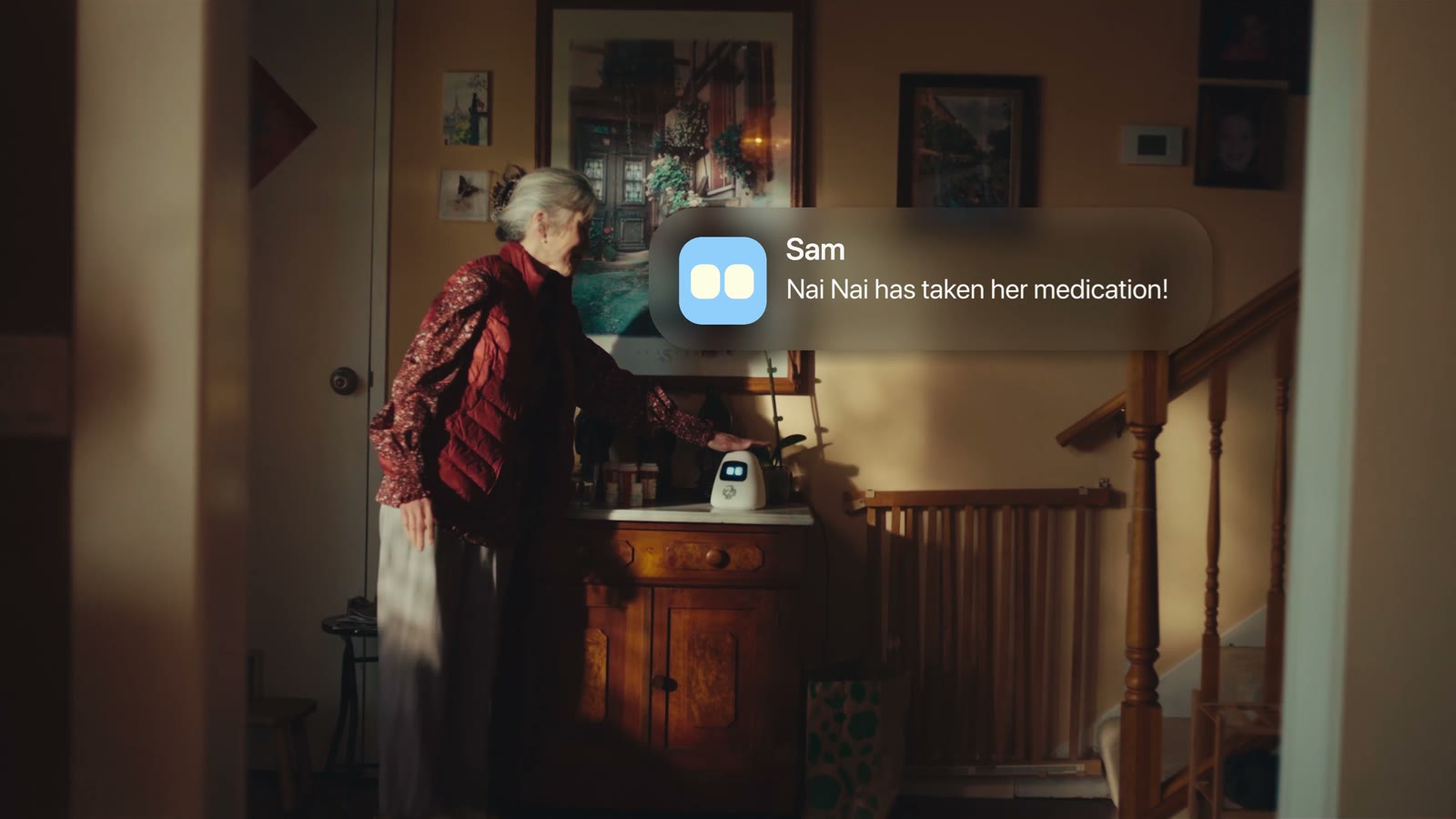 An older adult taking medication beside Sam at home.