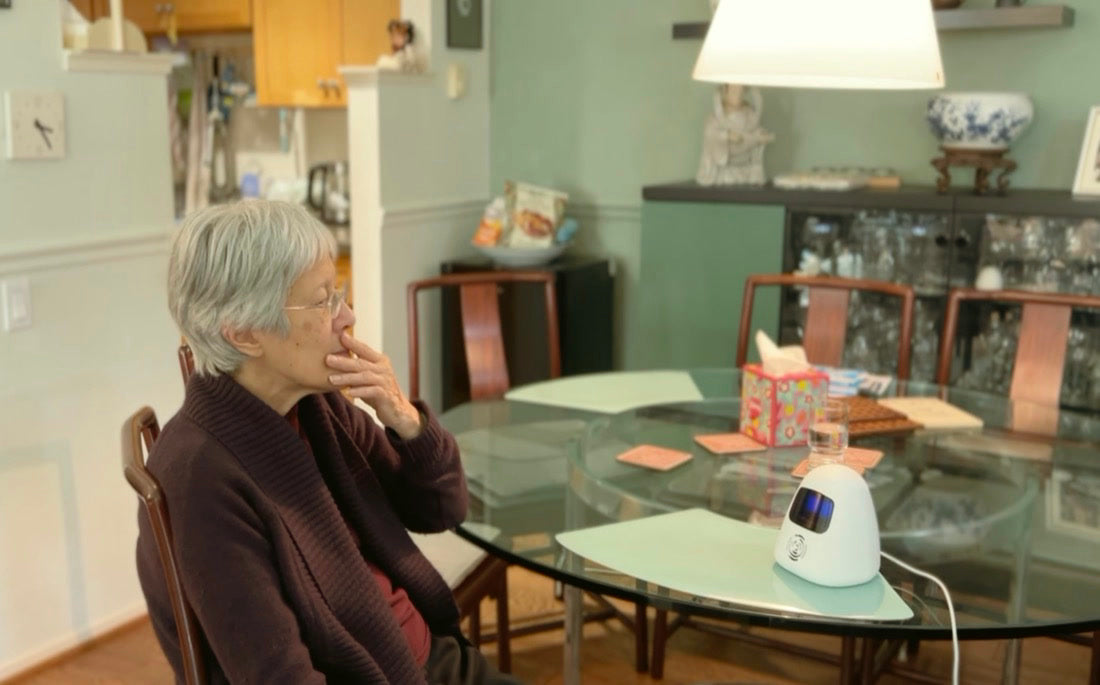 A woman sitting with Sam at her dining table
