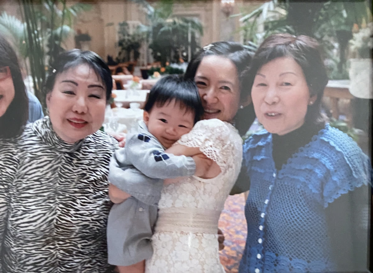 A grandma and family holding a smiling baby.